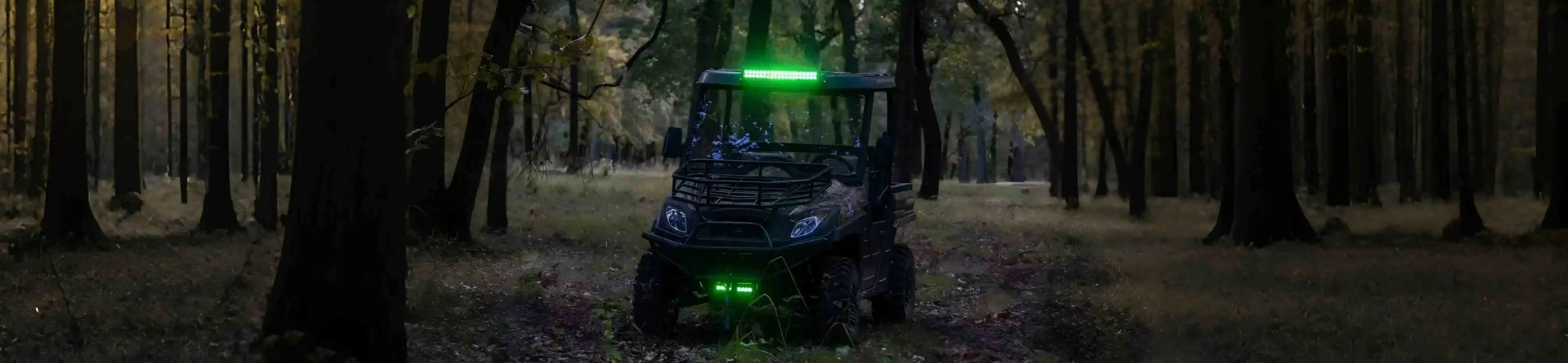 An all-terrain UTV parked on a dense forest trail, showcasing its Dual A-Arm independent suspension designed for rugged woods navigation.