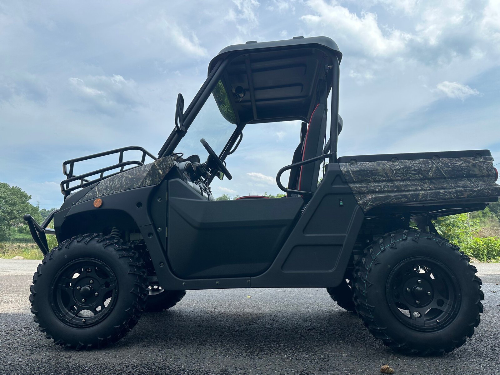 An electric UTV with Dual A-Arm independent suspension parked on a paved driveway, showcasing its rugged off-road chassis architecture.