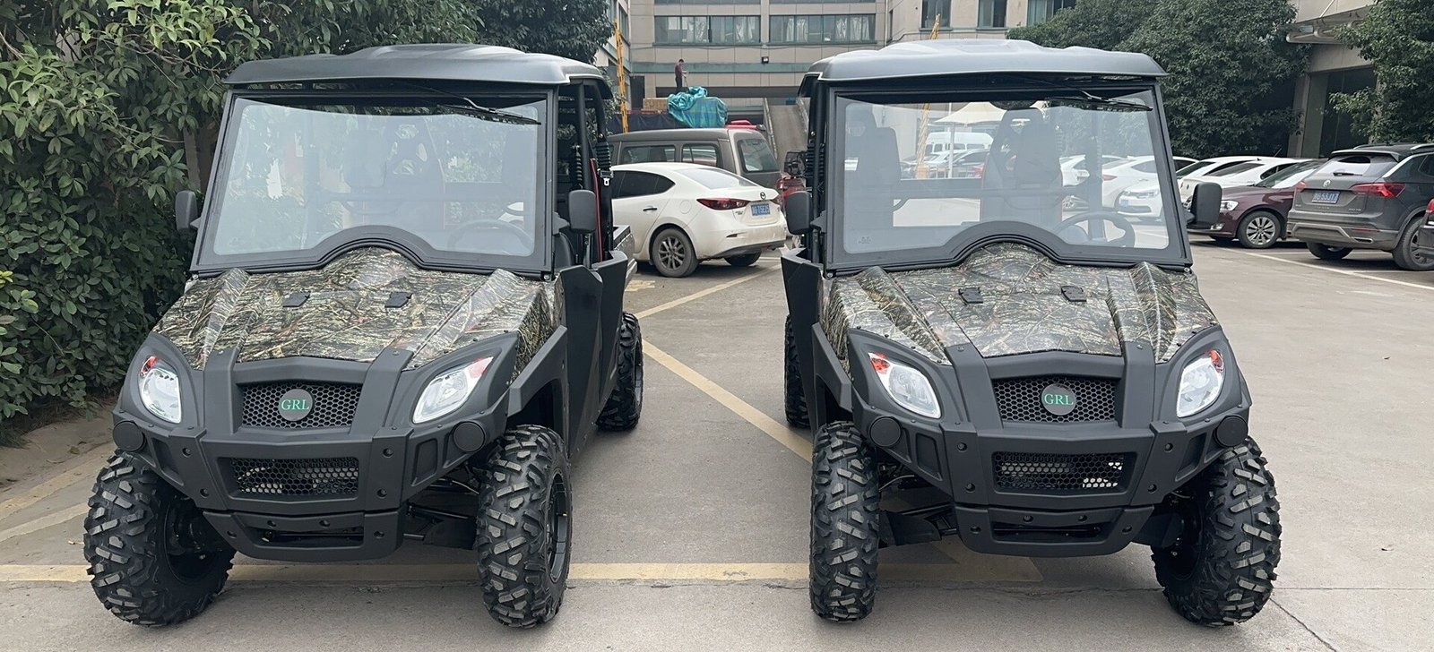 Two camouflage electric UTV buggies parked side by side, highlighting premium Dual A-Arm independent suspension for stable off-road operations.