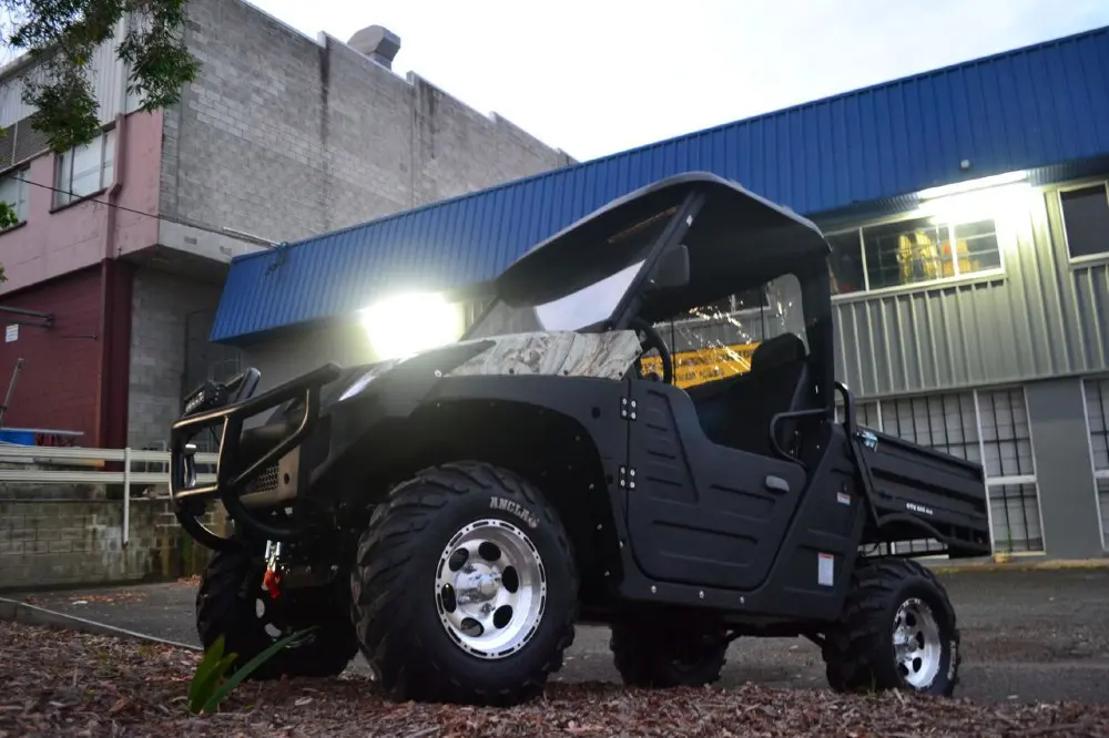 Off-road electric utility vehicle with high-intensity LED headlights navigating at night