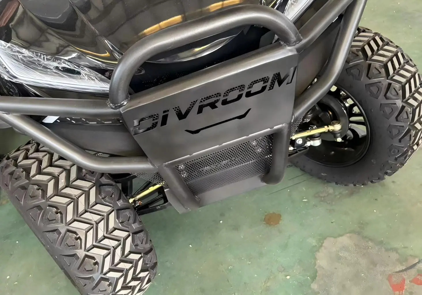 Heavy-duty steel bumper and all-terrain tires on a Greatwork off-road golf cart for superior protection and durability.