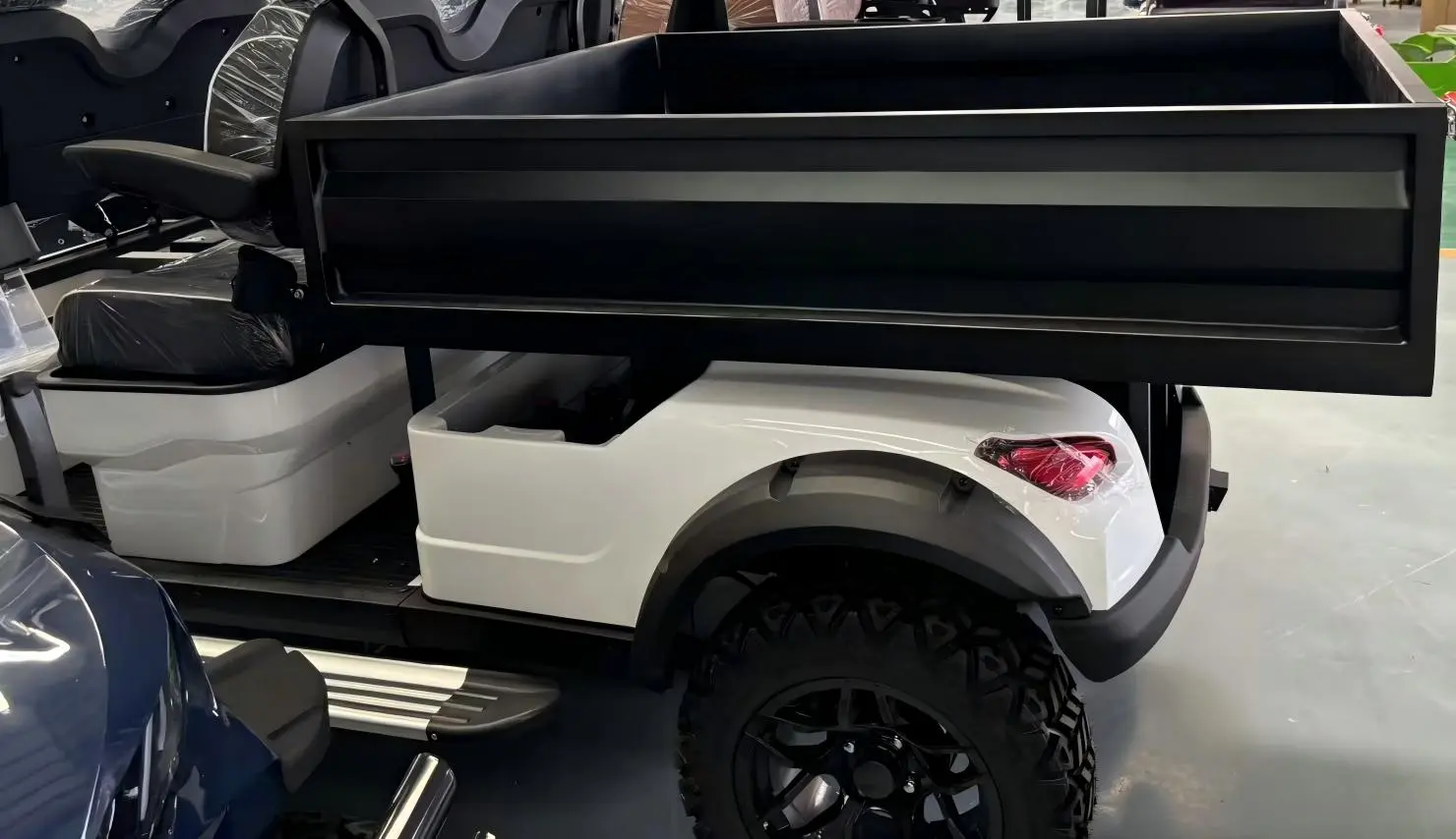 A 4-seater electric golf cart with a modular cargo bed design for efficient material transport.