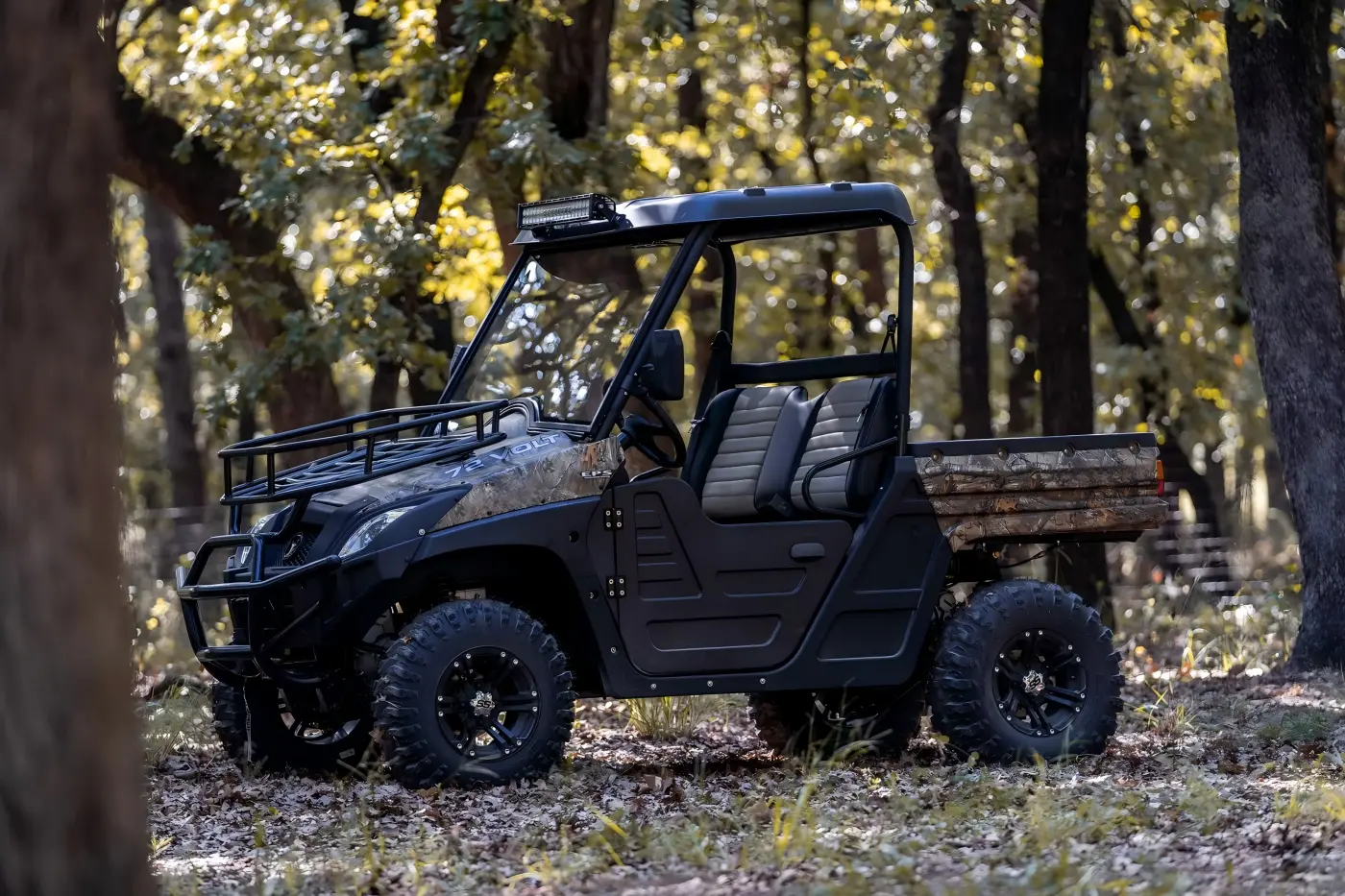 Side-rear view of a gasoline UTV parked in a woodland environment for farm work and trail riding
