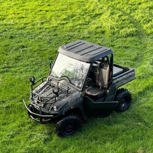 An electric UTV driving on a green pasture, demonstrating zero-emission operations in ecologically sensitive zones.