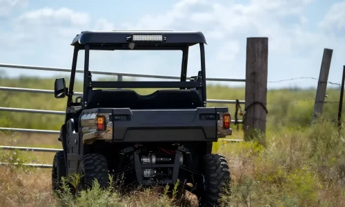 A fuel-powered UTV performing farm duties and off-road tasks in an outdoor field, demonstrating high load capacity and all-terrain versatility.